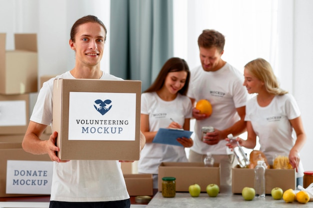 smiley male volunteer holding box with donations