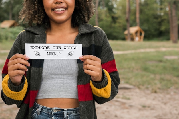 smiley woman holding a piece of paper while camping