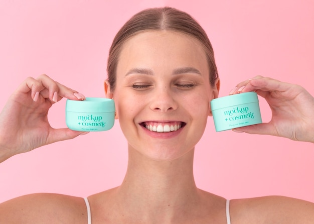 PSD smiley woman holding skincare products front view