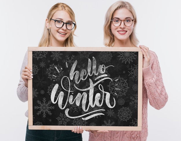 Smiley young girls holding mock-up sign