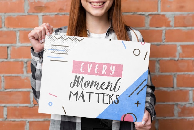 Smiling female holding mock-up