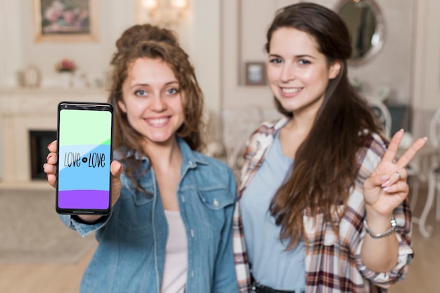 PSD ragazze sorridenti che presentano il modello di smartphone