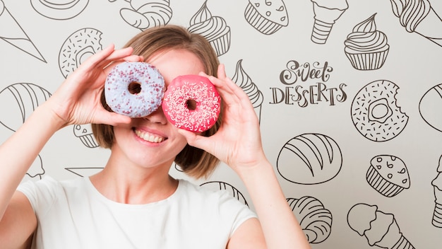 Smiling woman looking through donuts