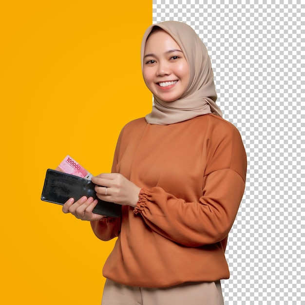 お金の紙幣でいっぱいの財布を示すオレンジ色のシャツを着た笑顔の若いアジア女性