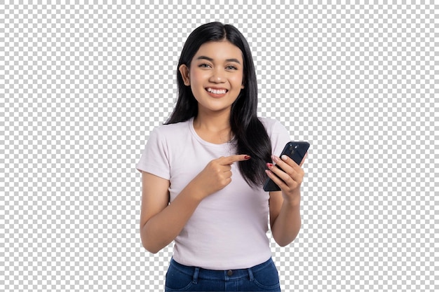 透明な背景に隔離されたモバイルアプリやオンラインサービスを宣伝しながらスマートフォンの画面を指さしている笑顔の若いアジア人女性