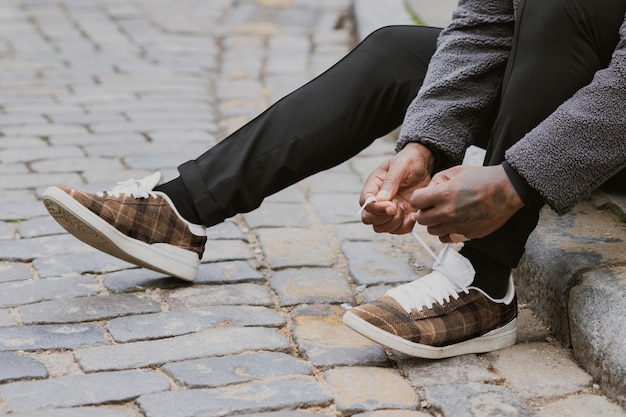 Sneaker schoen mockups man het binden van schoenveters op de straat psd