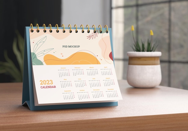 Spiral desk calendar mockup on a wooden table with a home scene background in realistic 3D render