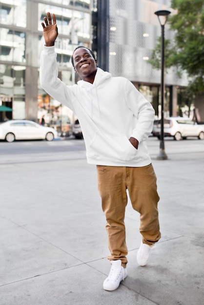Sporty man hoodie mockup psd witte en bruine broek in de stad kleding shoot