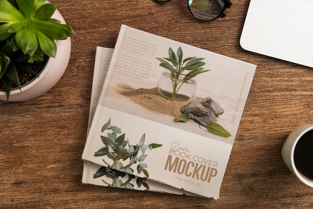 PSD square book mock-up on wooden desk with stationery