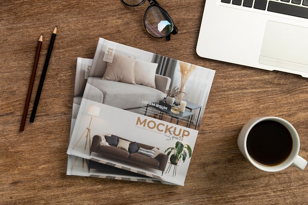 PSD square book mock-up on wooden desk with stationery