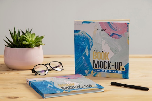 Square book mock-up on wooden office desk