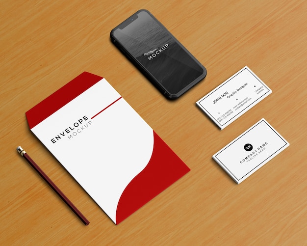 Concetto di cancelleria con busta e smartphone mockup