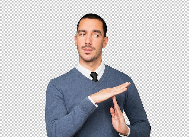 Stressed young man making a time out gesture with his hands
