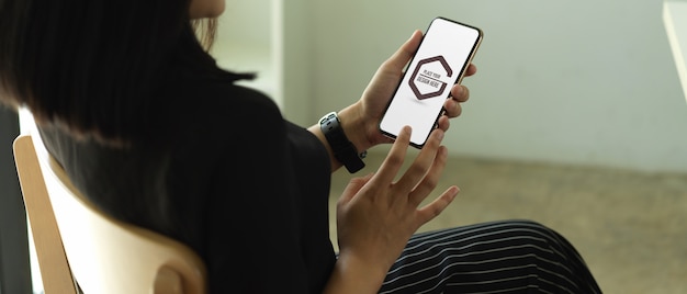 Student hands using mockup smartphone in coffee shop