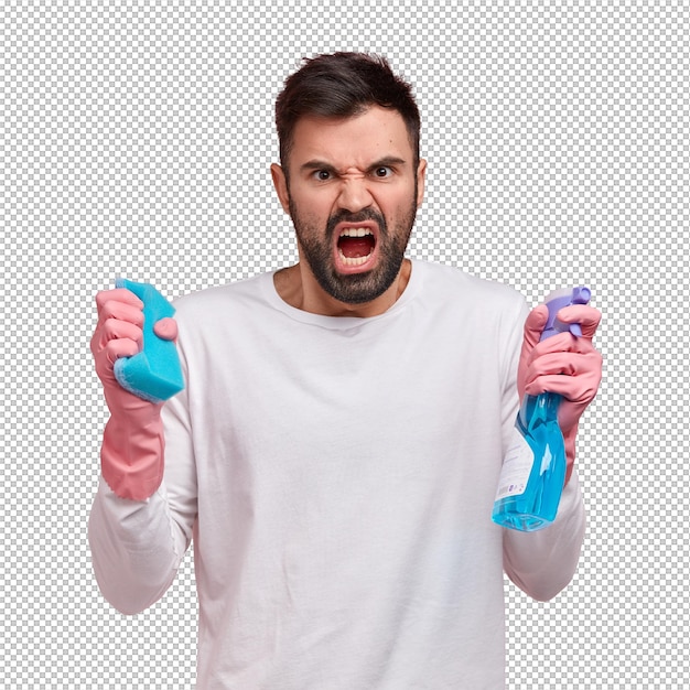 studio shot of angry unshaven young man opens mouth from anger holds spray and sponge frowns face in discontent expreses negative emotions