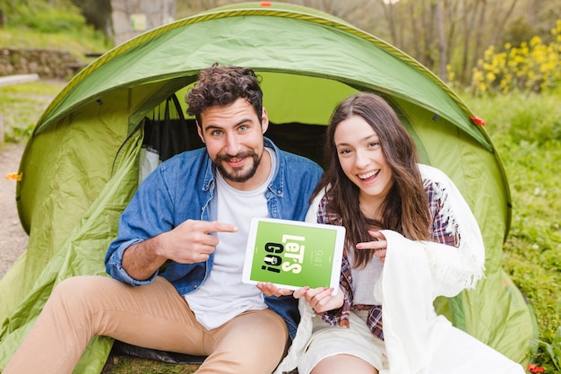 Summer camp mockup with couple pointing at tablet