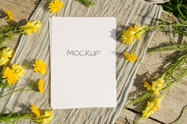 PSD summer stationery mockup greeting card or wedding invitation with yellow flowers on a old wood space in rustic style and natural