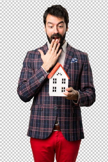 PSD Удивленный хорошо одет мужчина держит маленький дом