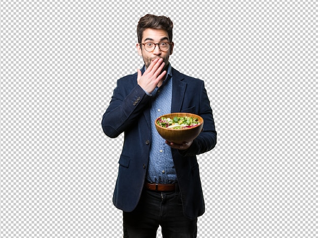 Surprised young man holding a salad bowl