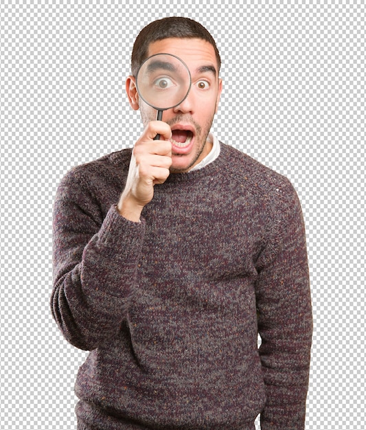 surprised young man using a magnifying glass