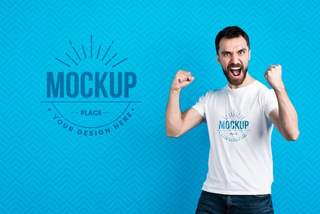 PSD uomo di mock-up di t-shirt che mostra il gesto di vittoria