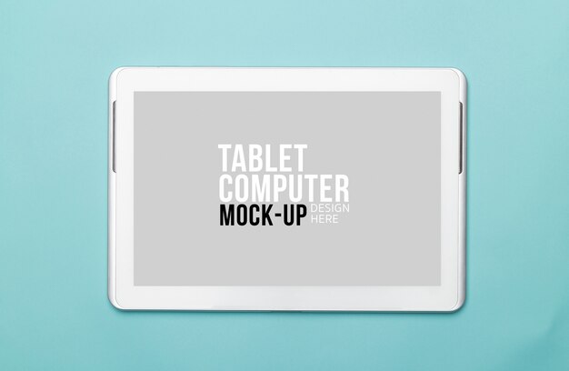 Tablet computer with screen mockup for your design on blue background.