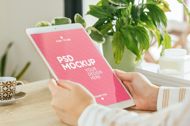 PSD tablet mockup held by a woman in the living room