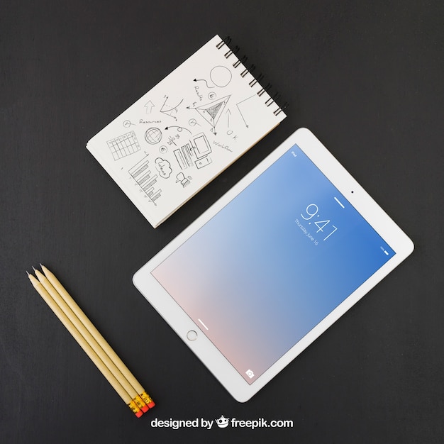 Tablet, matite e taccuino con disegno