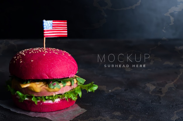вкусный гамбургер с маленькими американскими флагами на камне