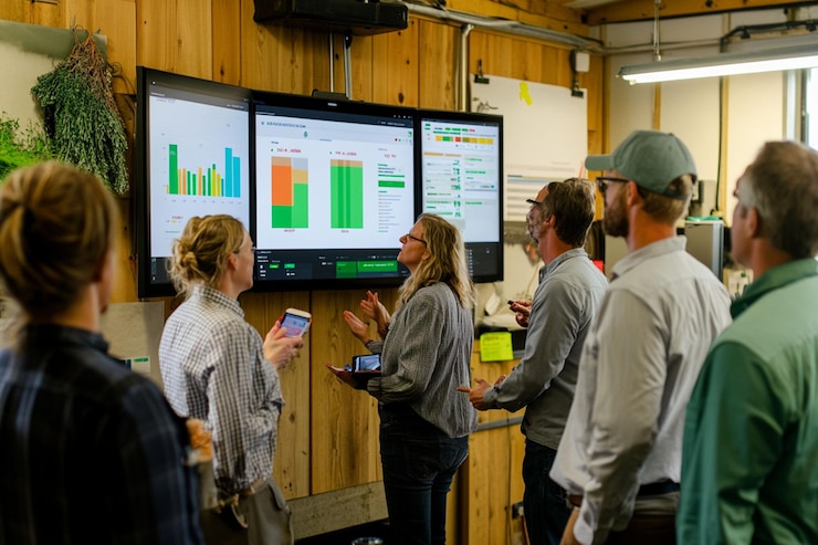 PSD team reviewing data on large screen displays in a rustic office