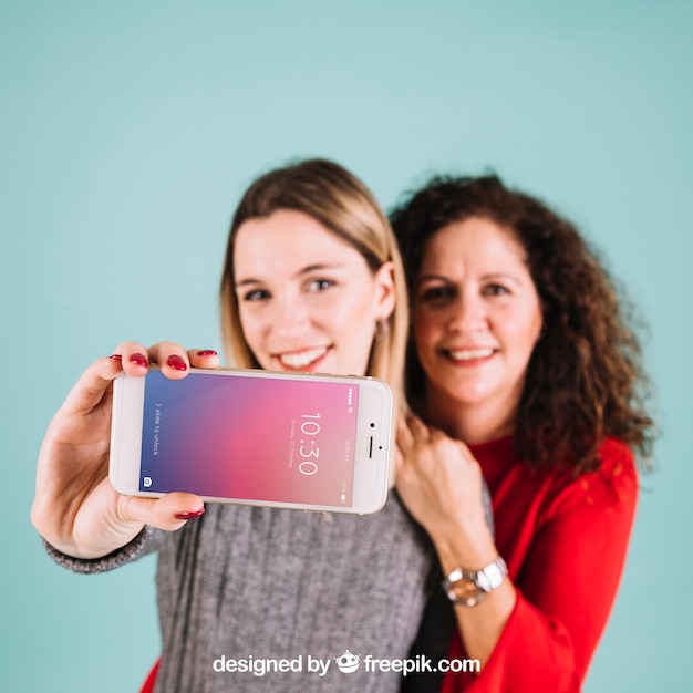 PSD Технологический макет с женщинами, представляющими смартфон