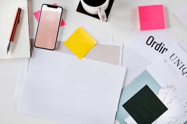 Telefon komórkowy na biurku z papierową makietą