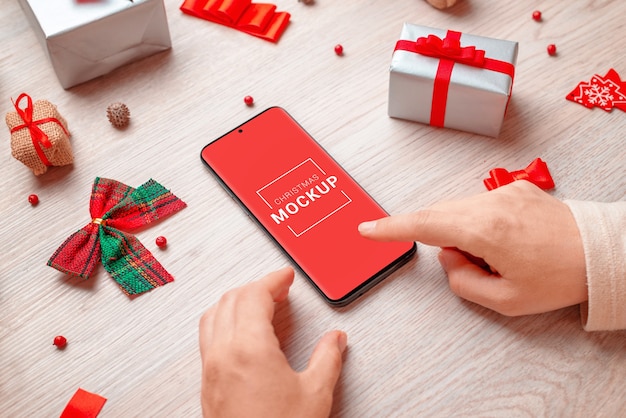 Telefoonmodel omringd door kerstversieringen en geschenken