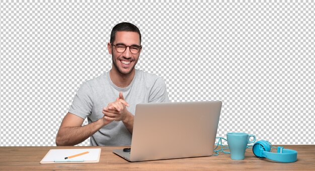 Tevreden jonge man zit aan zijn bureau