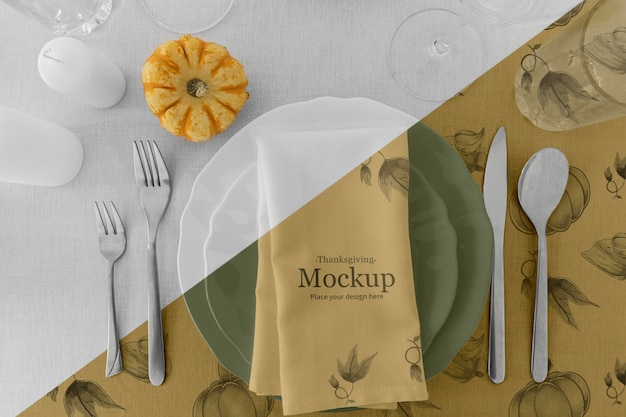 Thanksgiving dinner table arrangement with cutlery and pumpkin