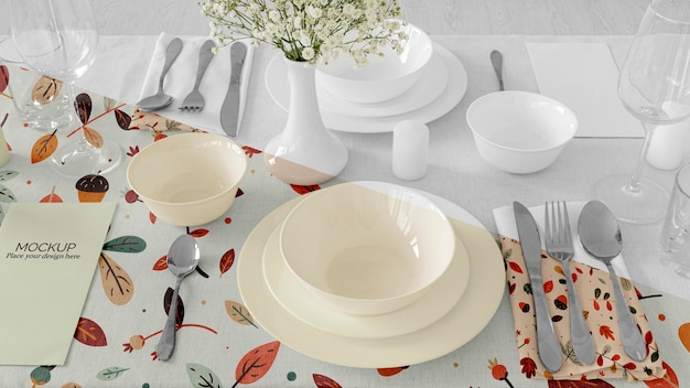 Thanksgiving dinner table arrangement with plates and flower vase