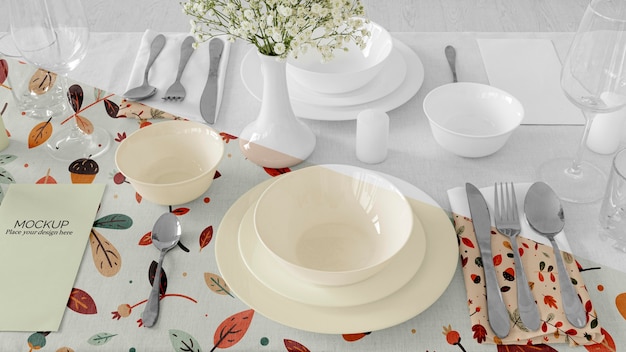 Thanksgiving dinner table arrangement with plates and flower vase