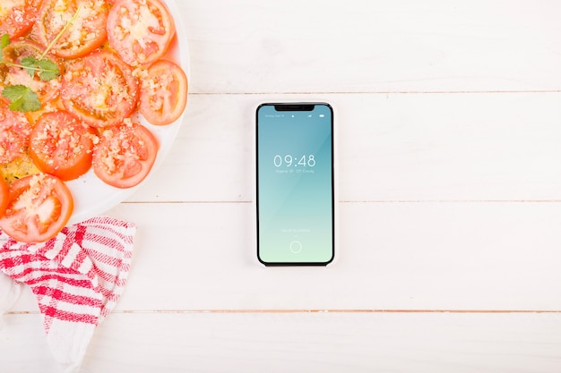 Tomatoes on plate and smartphone