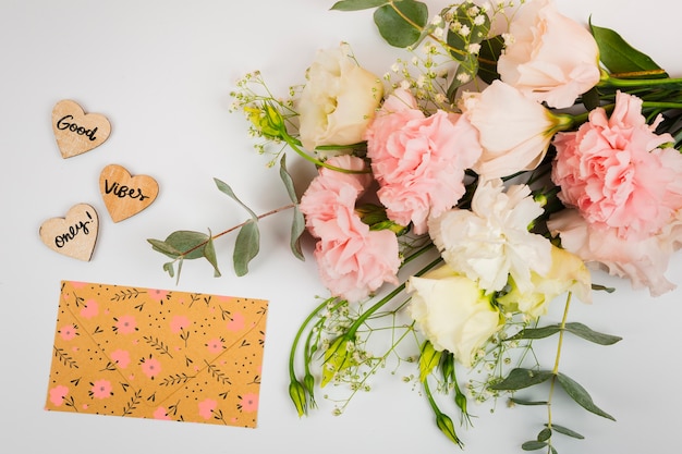 Top view bouquet of flowers next to cute envelope