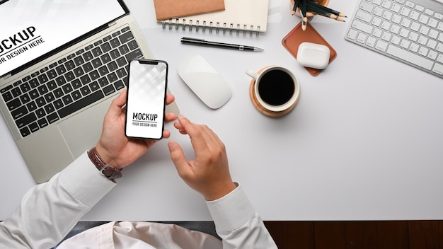 Top view of businessman hands using smartphone mockup