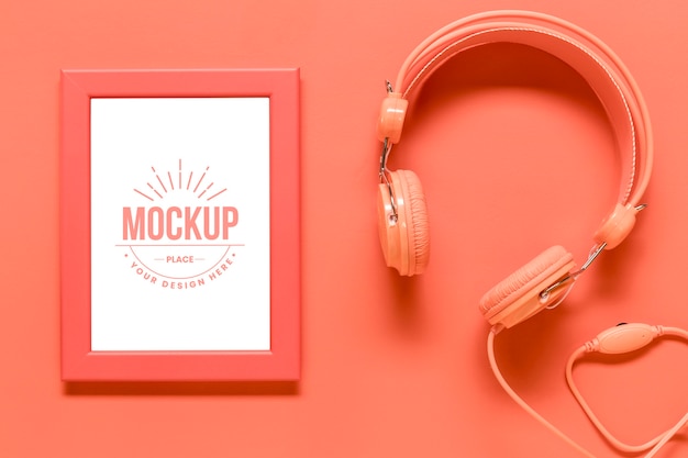 top view coral arrangement with frame mock-up and headphones