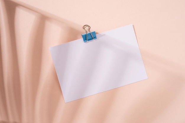 Top view desk arrangement. Time management, planning concept. Minimal style blank paper for notes or calendar on beige background for mockup design, shadow overlay