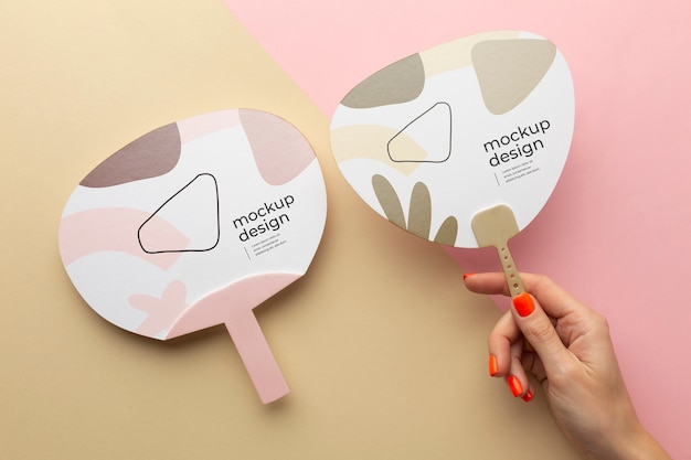 Top view of female hands holding mock-up paper fan