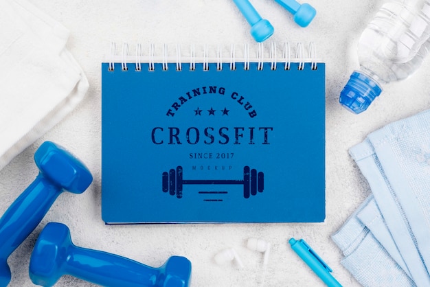 Top view of fitness notebook with jumping rope and weights