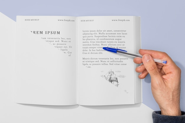 開いた本のモックアップにペンを持つ平面図手