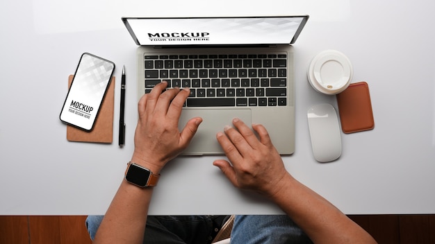 Top view of male hands typing on laptop keyboard mockup