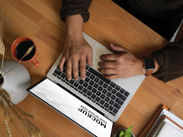 PSD top view of male hands typing on laptop mockup