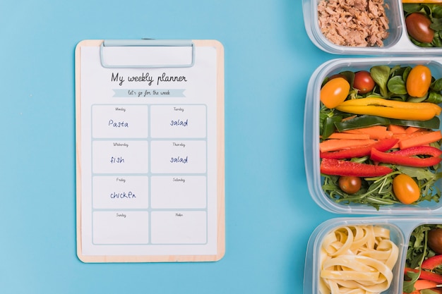 Top view of meals with vegetable and notepad