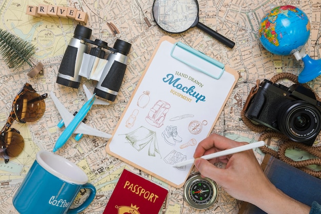 Top view of mock-up notepad with traveling essentials and camera