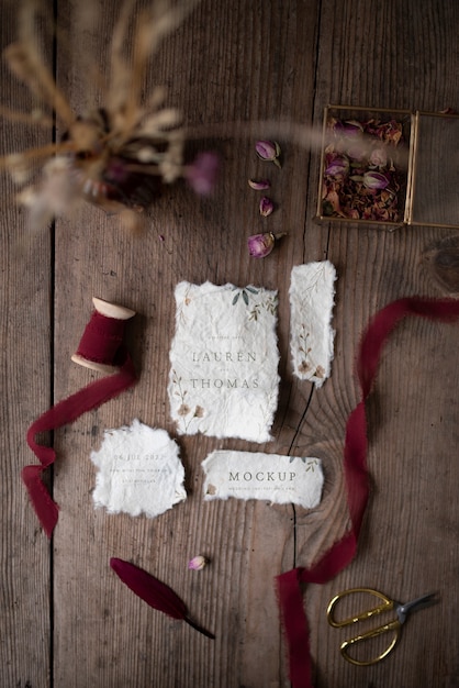 Top view of mock-up rustic paper wedding invitation with leaves and flowers